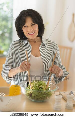 Stock Photography - Senior woman preparing salad. Fotosearch