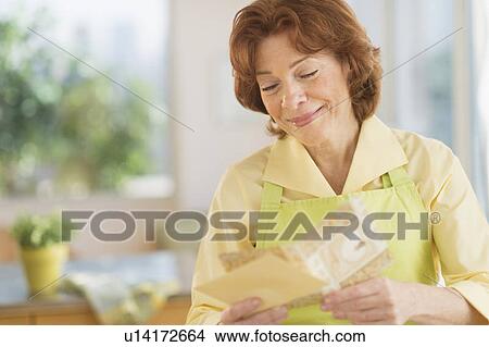 Senior woman reading greeting card View Large Photo Image Picture - Senior woman reading greeting card. Fotosearch