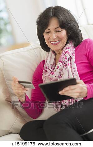 Stock Photograph - Senior woman with digital tablet and credit card. Fotosearch