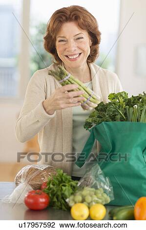 Senior woman with groceries in kitchen View Large Photo Image Stock Image - Senior woman with groceries in kitchen. Fotosearch