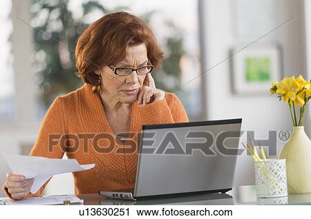 Senior woman working on laptop at home View Large Photo Image Stock Image - Senior woman working on laptop at home. Fotosearch