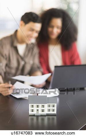 Smiling couple planning home ownership with model home View Large Photo Image Stock Image - Smiling couple planning home ownership with model home. Fotosearch