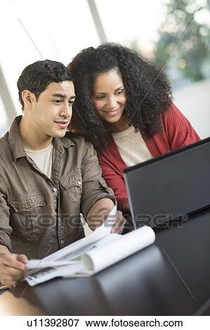 Smiling couple planning home ownership with model home View Large Photo Image Stock Photo - Smiling couple planning home ownership with model home. Fotosearch