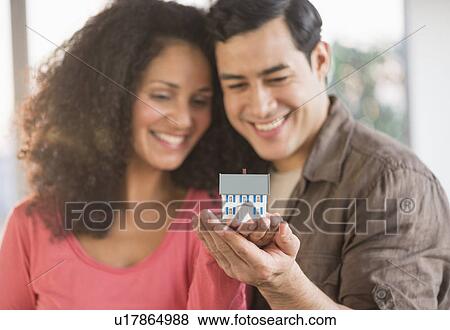 Smiling couple with model home View Large Photo Image Stock Photo - Smiling couple with model home. Fotosearch