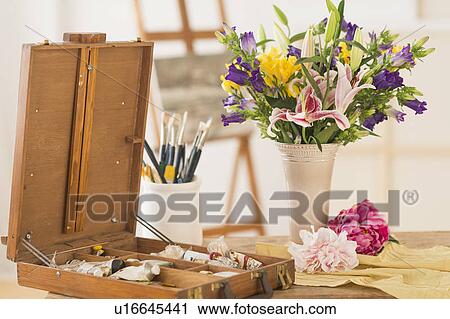 Stock Image - Still life with fresh bouquet and box of paints. Fotosearch