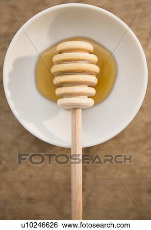 Stock Photograph - Studio shot of honey on saucer. Fotosearch