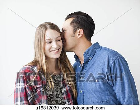 Studio Shot portrait of young couple whispering and smiling View Large Photo Image Stock Photo - Studio Shot portrait of young couple whispering and smiling. Fotosearch