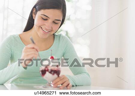 Stock Image - Teenage girl (16-17) eating ice-cream. Fotosearch