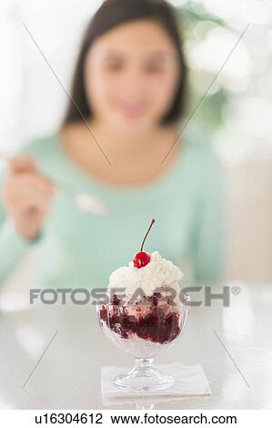 Stock Image - Teenage girl (16-17) eating ice-cream. Fotosearch