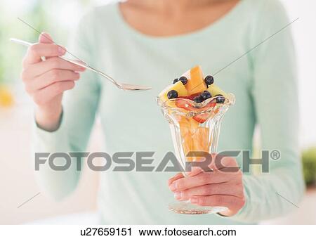 Teenage girl eating fruit dessert View Large Photo Image Stock Image - Teenage girl eating fruit dessert. Fotosearch