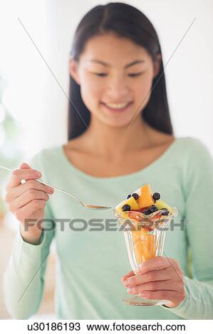 Teenage girl eating fruit dessert View Large Photo Image Stock Image - Teenage girl eating fruit dessert. Fotosearch