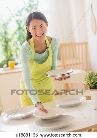 Stock Photography - Teenage girl setting table. Fotosearch