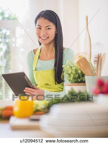 Teenage girl using digital tablet in kitchen View Large Photo Image Stock Image - Teenage girl using digital tablet in kitchen. Fotosearch