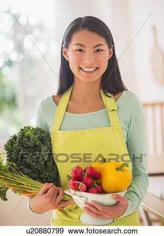 Teenage girl with bunch of vegetables in kitchen View Large Photo Image Stock Photo - Teenage girl with bunch of vegetables in kitchen. Fotosearch