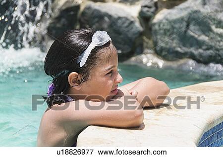 Stock Photo - View of girl (8-9 years) wearing swimming goggle. Fotosearch
