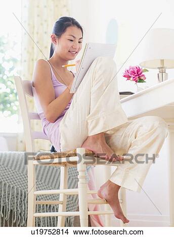 Picture - View of teenage girl ( 16-17 years) studying at home. Fotosearch