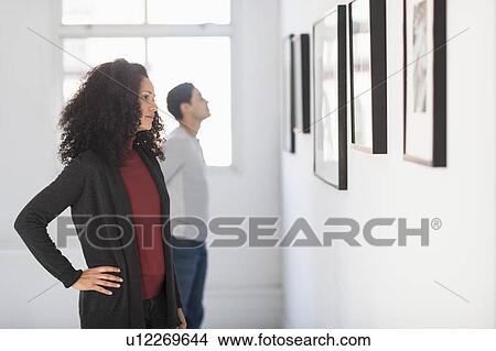 Visitors looking at artworks in gallery View Large Photo Image Picture - Visitors looking at artworks in gallery. Fotosearch