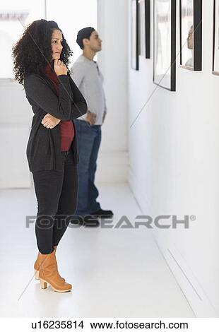 Visitors looking at artworks in gallery View Large Photo Image Picture - Visitors looking at artworks in gallery. Fotosearch
