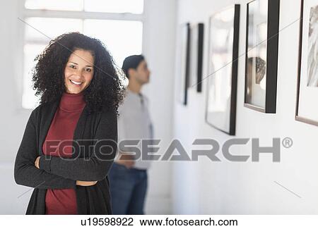 Stock Image - Visitors looking at artworks in gallery. Fotosearch