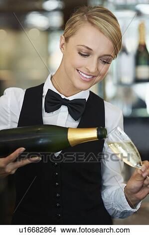 Picture - Waitress pouring champagne into champagne flute. Fotosearch