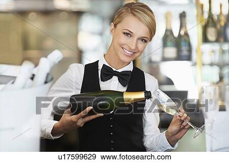 Waitress pouring champagne into champagne flute View Large Photo Image Stock Photo - Waitress pouring champagne into champagne flute. Fotosearch