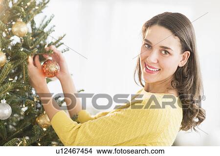 Woman decorating christmas tree View Large Photo Image Picture - Woman decorating christmas tree. Fotosearch