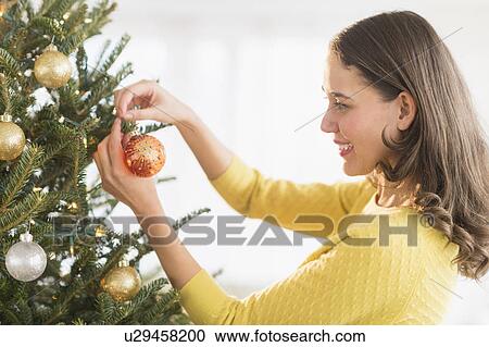 Woman decorating christmas tree View Large Photo Image Stock Image - Woman decorating christmas tree. Fotosearch