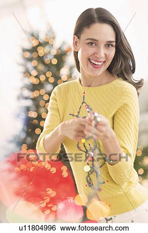 Woman decorating christmas tree View Large Photo Image Stock Photograph - Woman decorating christmas tree. Fotosearch