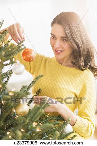 Woman decorating christmas tree View Large Photo Image Stock Photograph - Woman decorating christmas tree. Fotosearch