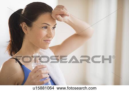 Woman drinking water in gym View Large Photo Image Picture - Woman drinking water in gym. Fotosearch