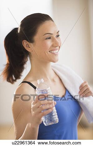 Picture - Woman drinking water in gym. Fotosearch
