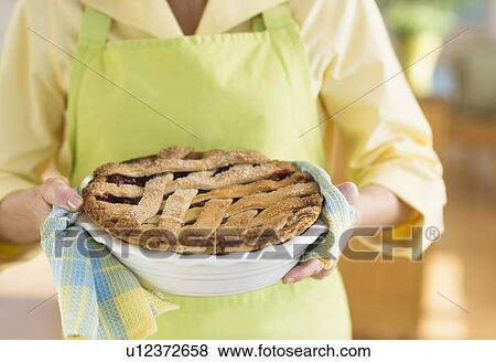 Stock Photo - Woman holding freshly baked cake. Fotosearch