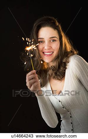 Stock Image - Woman holding sparkler. Fotosearch