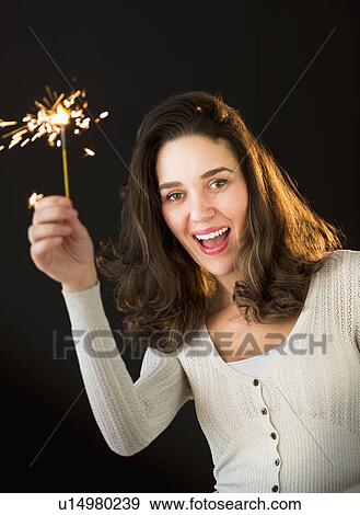 Stock Photo - Woman holding sparkler. Fotosearch