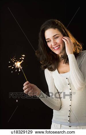 Woman holding sparkler View Large Photo Image Stock Photo - Woman holding sparkler. Fotosearch