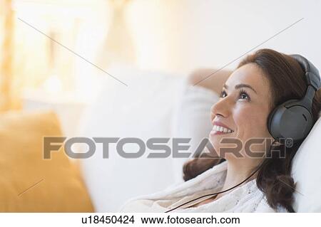 Picture - Woman listening to music at home. Fotosearch
