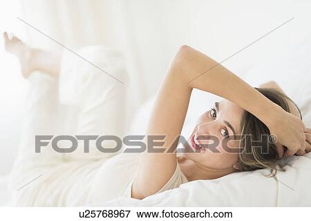 Woman lying in bed View Large Photo Image Stock Photo - Woman lying in bed. Fotosearch