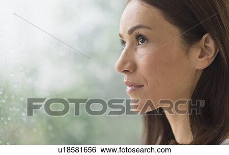 Woman next to rainy window View Large Photo Image Stock Photograph - Woman next to rainy window. Fotosearch