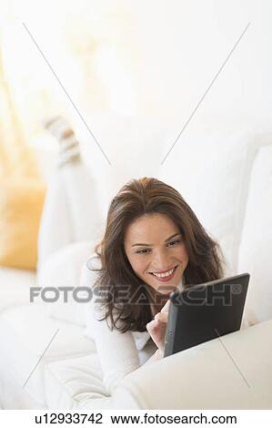 Woman on sofa using tablet pc View Large Photo Image Stock Image - Woman on sofa using tablet pc. Fotosearch