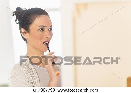 Stock Photo - Woman painting at easel. Fotosearch
