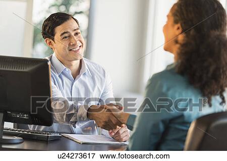 Woman shaking hand with man at desk View Large Photo Image Stock Photo - Woman shaking hand with man at desk. Fotosearch
