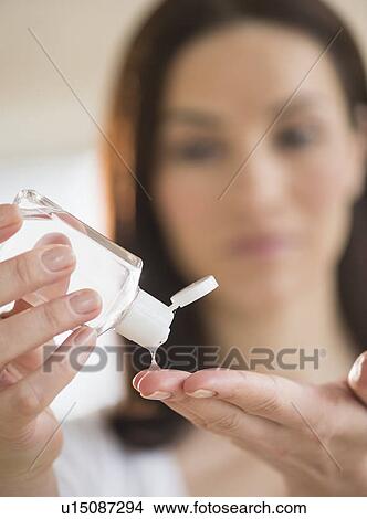 Woman using hand sanitizer View Large Photo Image Picture - Woman using hand sanitizer. Fotosearch
