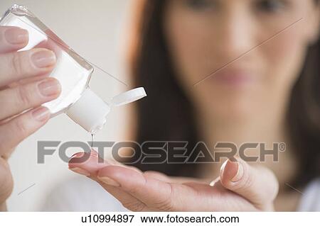 Woman using hand sanitizer View Large Photo Image Stock Photo - Woman using hand sanitizer. Fotosearch