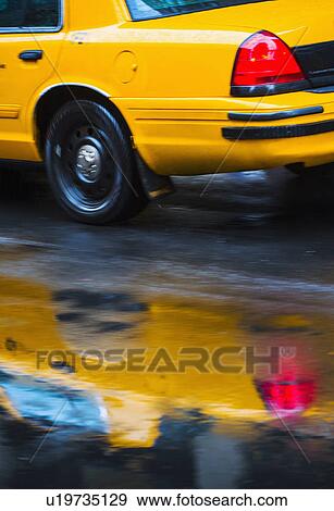 Yellow cab reflecting in rain puddle View Large Photo Image Stock Photo - Yellow cab reflecting in rain puddle. Fotosearch