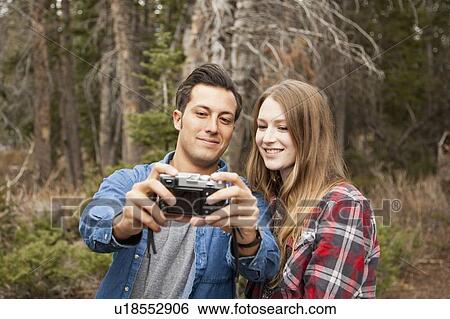 Young couple self photographing in non-urban scene View Large Photo Image Stock Photograph - Young couple self photographing in non-urban scene. Fotosearch