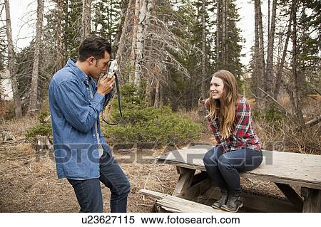 Young man photographing his girlfriend in non-urban scene View Large Photo Image Stock Photography - Young man photographing his girlfriend in non-urban scene. Fotosearch
