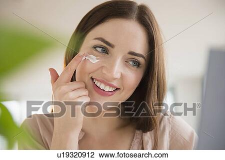 Young woman applying face cream View Large Photo Image Stock Image - Young woman applying face cream. Fotosearch