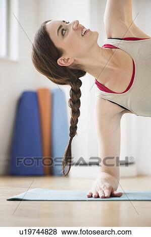 Young woman exercising at home View Large Photo Image Stock Photo - Young woman exercising at home. Fotosearch