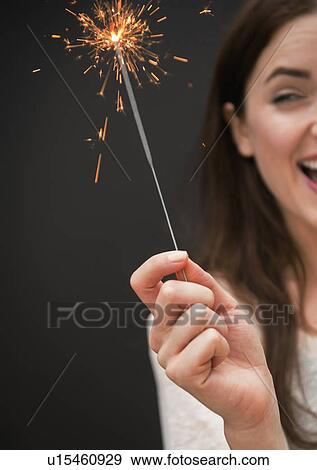 Stock Photo - Young woman holding firework. Fotosearch