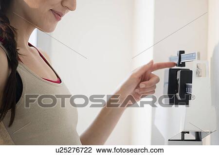 Stock Image - Young woman on scales. Fotosearch
